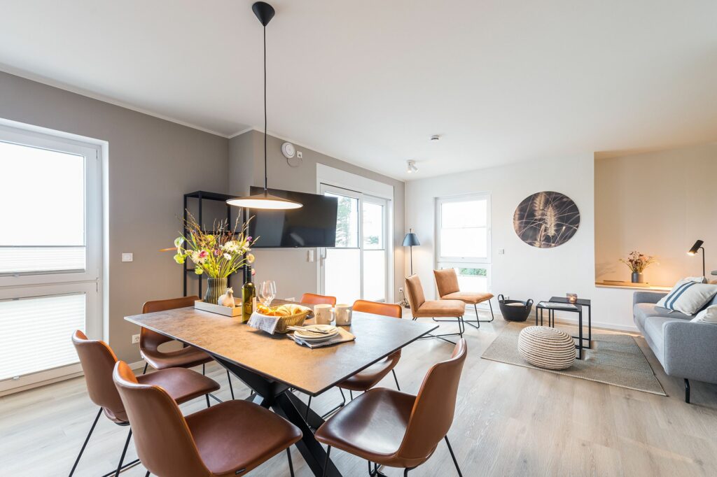 Gedeckter Esstisch mit Blick ins Wohnzimmer in Ferienwohnung Grömitz