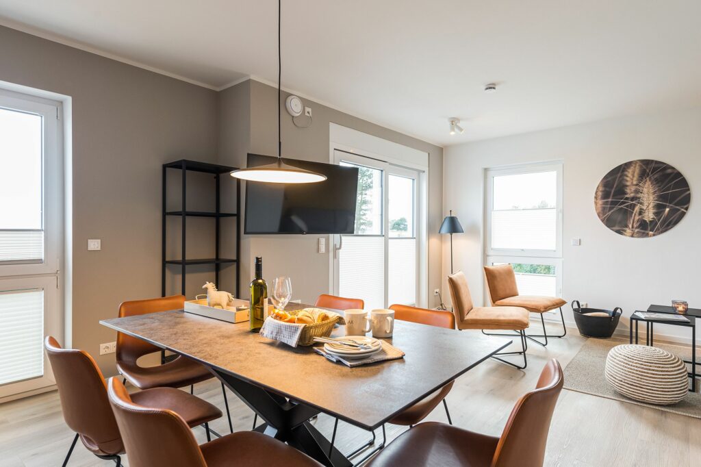 Gedeckter Esstisch mit Blick ins Wohnzimmer in Ferienwohnung Grömitz