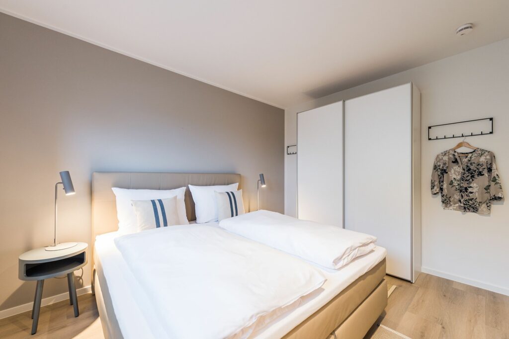 Schlafzimmer mit Doppelbett und Schrank in Ferienwohnung Grömitz