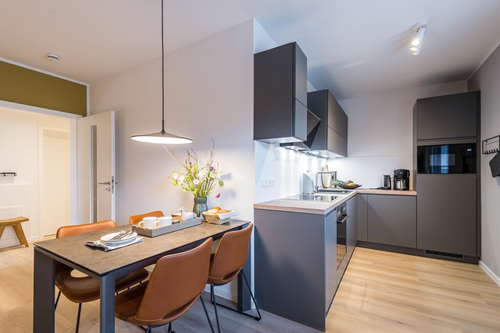 Moderne offene Küche mit Blick auf den Esstisch in Ferienwohnung Grömitz