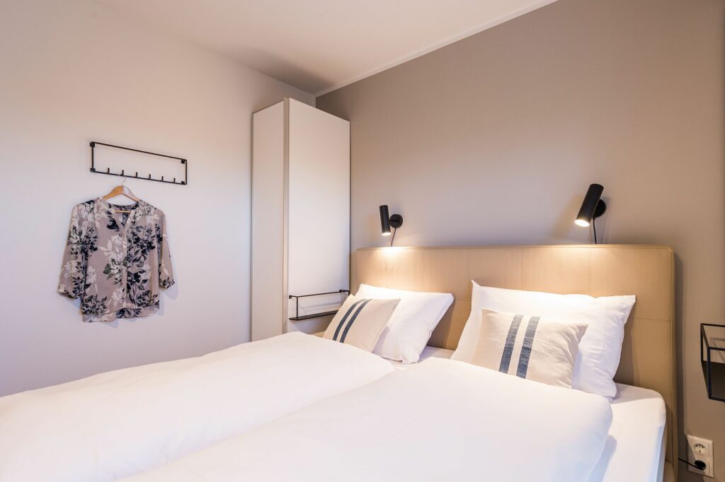 Schlafzimmer mit Doppelbett und Garderobe in Ferienwohnung Grömitz