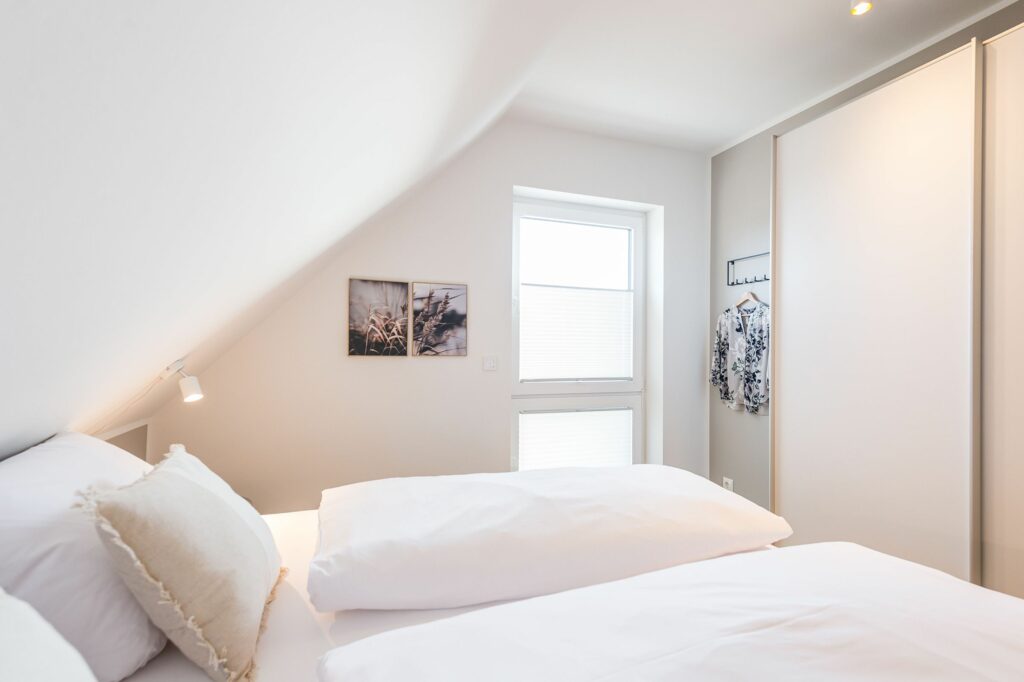 Schlafzimmer mit Schrank und Doppelbett in Ferienwohnung Grömitz
