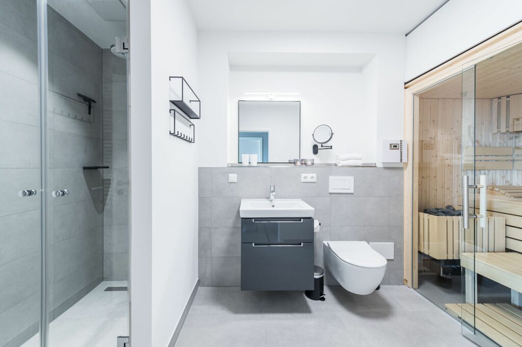 Badezimmer mit Waschbecken, Toilette und Sauna in Ferienwohnung Grömitz