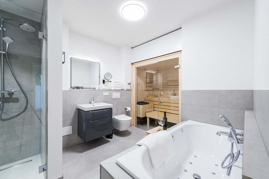 Badezimmer mit Wanne, Sauna und Weißwein in Ferienwohnung Grömitz