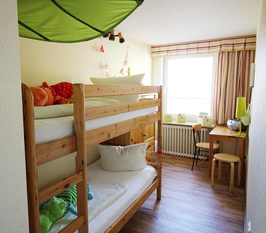 Ein Kinderzimmer in einer Ferienwohnung an der Ostsee. ein Hochbett bietet platz für zwei Kinder.