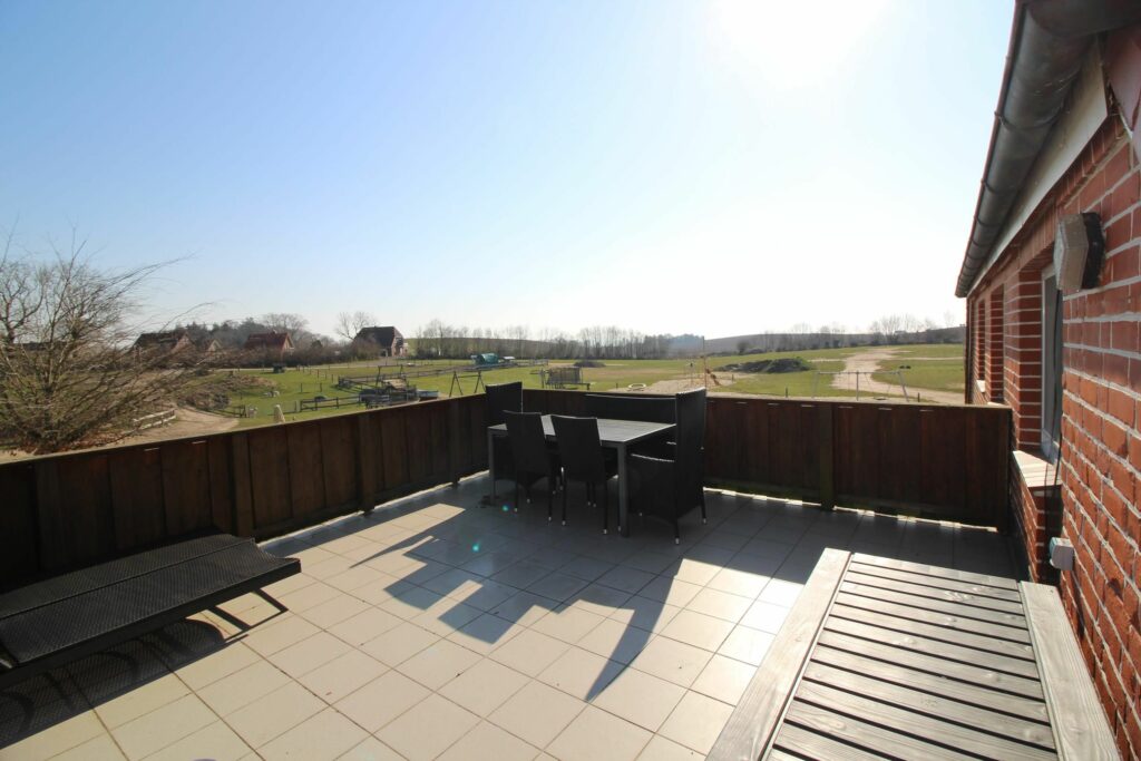 EinPanoramablick von dem Balkon einer Ferienwohnung hinweg über die weiten Spielflächen vom Bauer Martin Hof in Bliesdorf an der Ostsee.