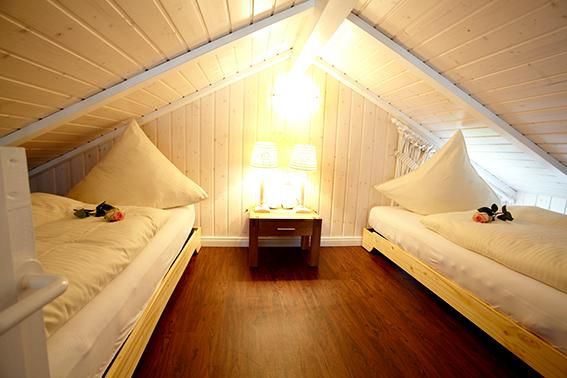 Schlafzimmer auf dem Dachboden einer Ferienwohnung mit zwei Betten.