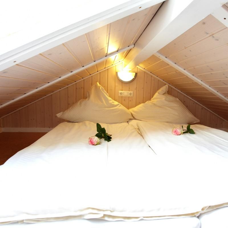 gemütliches doppelbett im dachstuhl von einem Wellnesshaus an der Ostsee