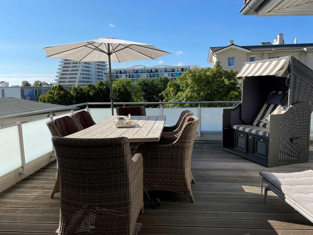 Balkon mit Flechtstuhl-Sitzgruppe und Strandkorb im Ferienhaus Grömitz