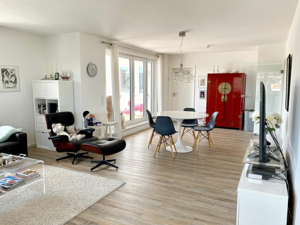 Wohnzimmer mit Ledersessel und rundem Esstisch für vier Personen im Ferienhaus Grömitz