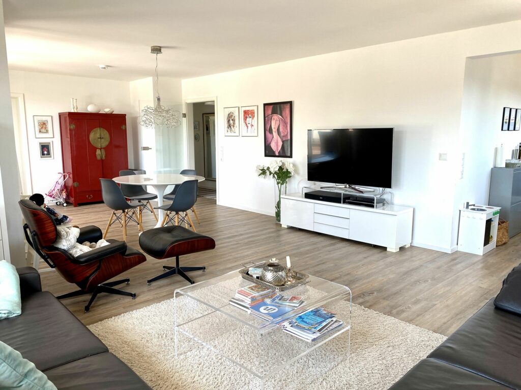Wohnzimmer mit Fernseher und flauschigem Teppich vor dem Ledersofa im Ferienhaus Grömitz