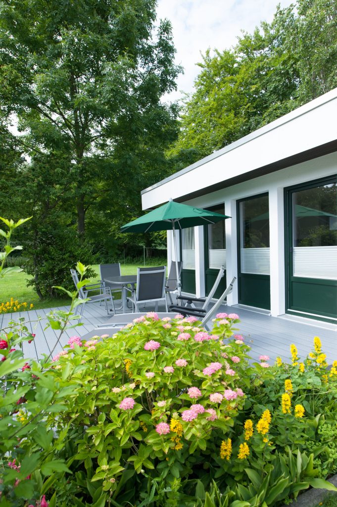 Ferienhaus Grömitz mit Terrasse mit Blumen und Sonnenschirm