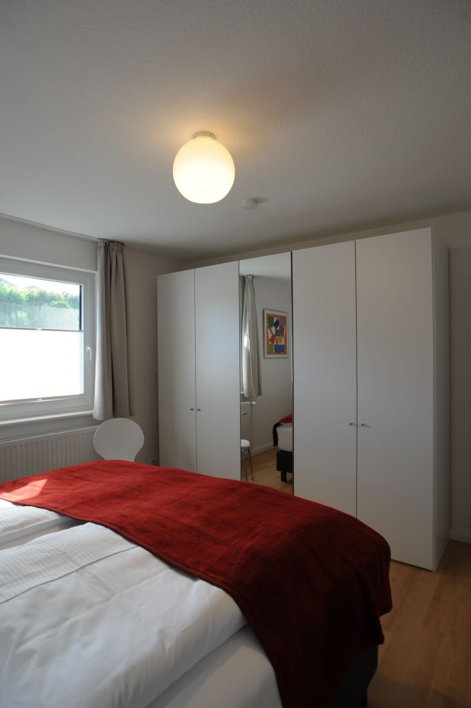 Schlafzimmer mit Spiegelschrank und Doppelbett in Ferienwohnung Grömitz